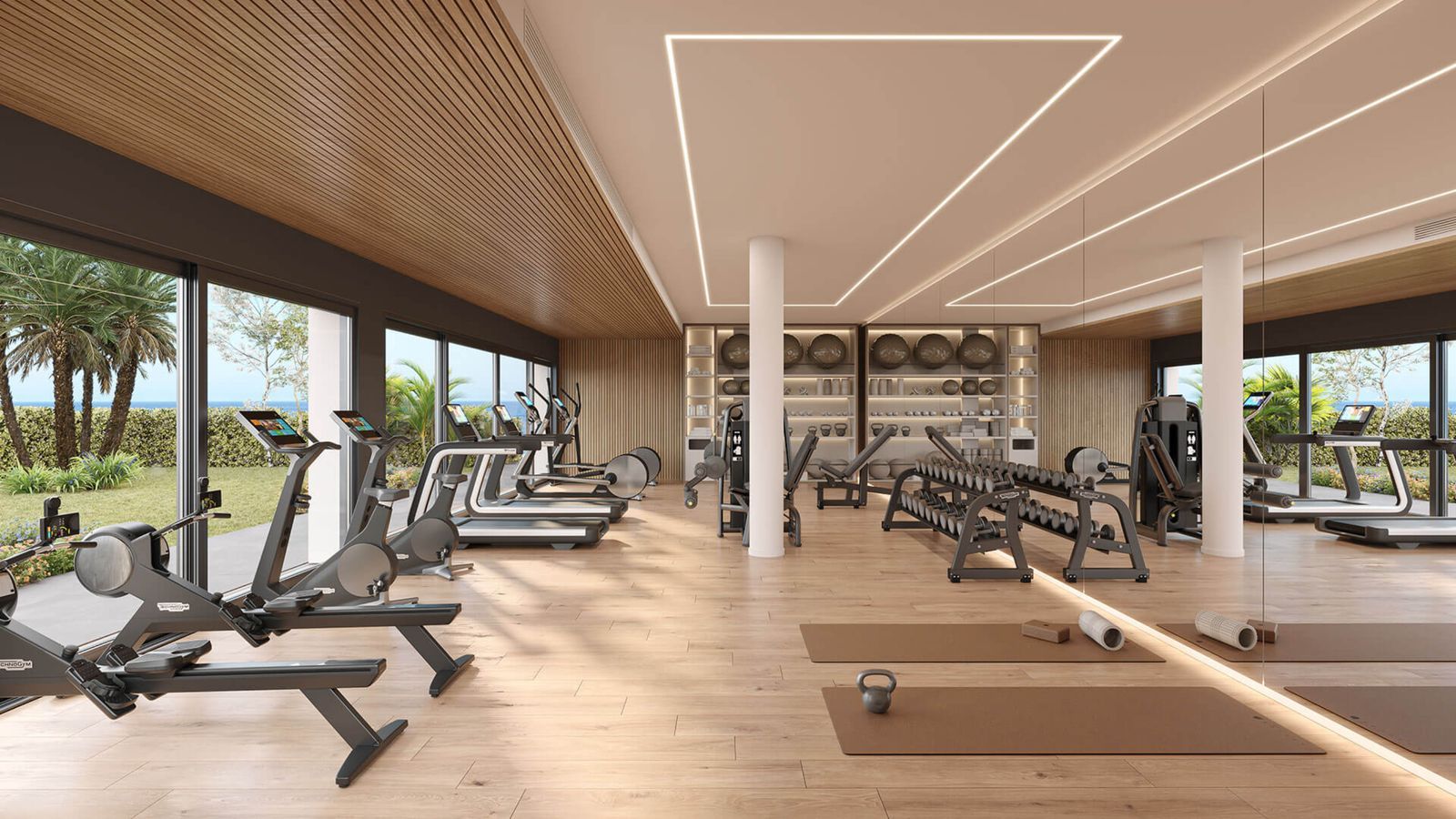 Moderne fitnesscenter på Alura Living med træningsudstyr og naturligt lys.